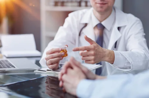 доктор дает таблетки пациенту для лечения энкопреза